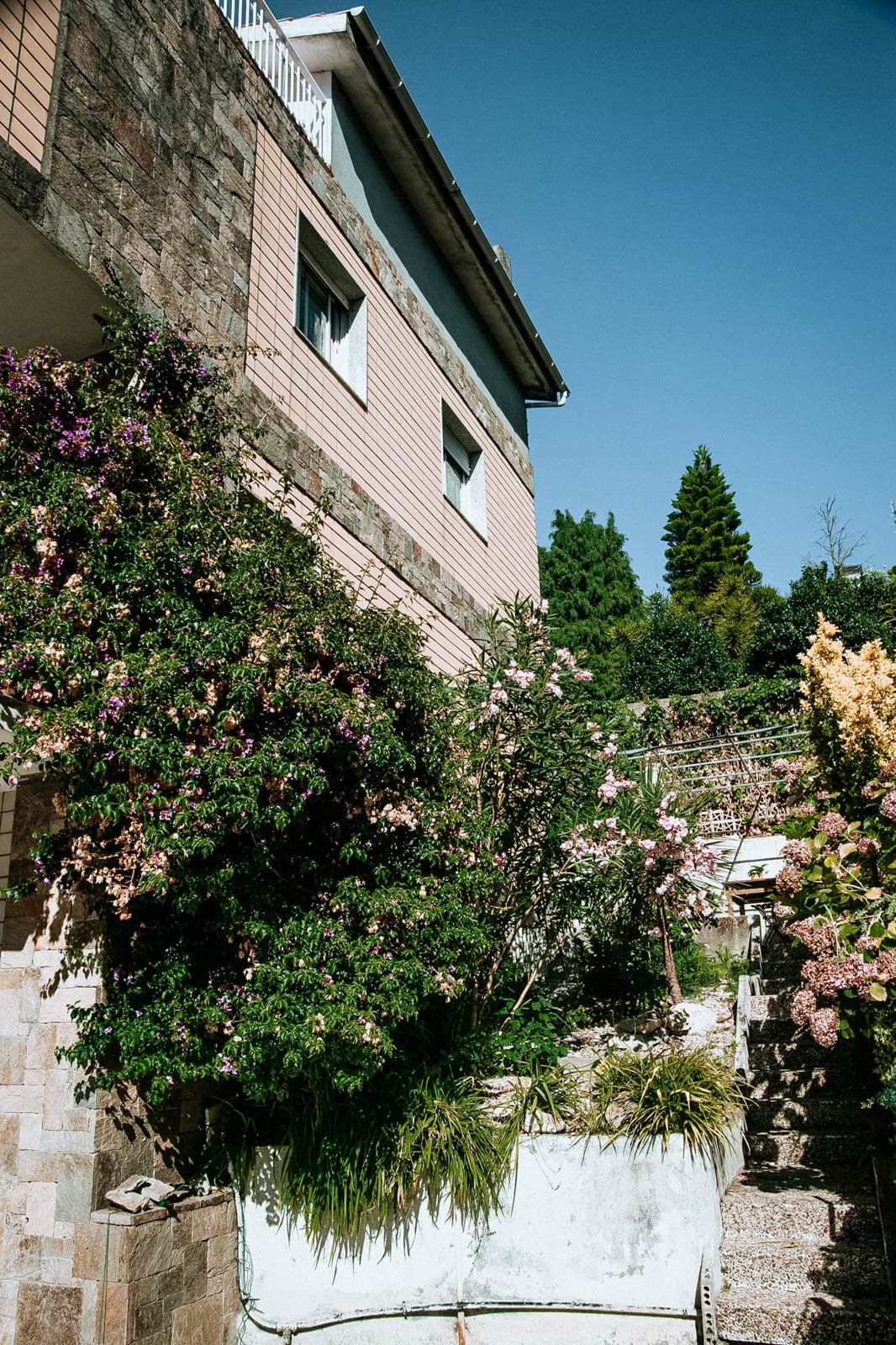 Fachada de La Casa del Castro con el jardín en flor