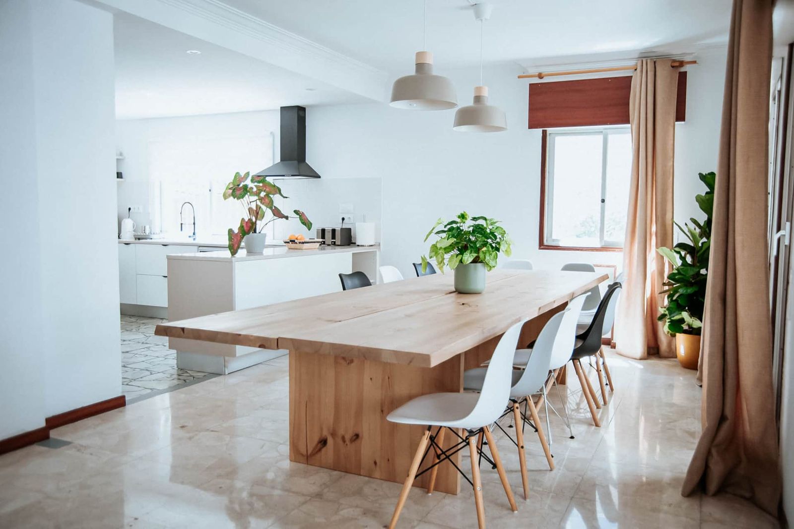 Comedor con mesa larga de madera y cocina abierta